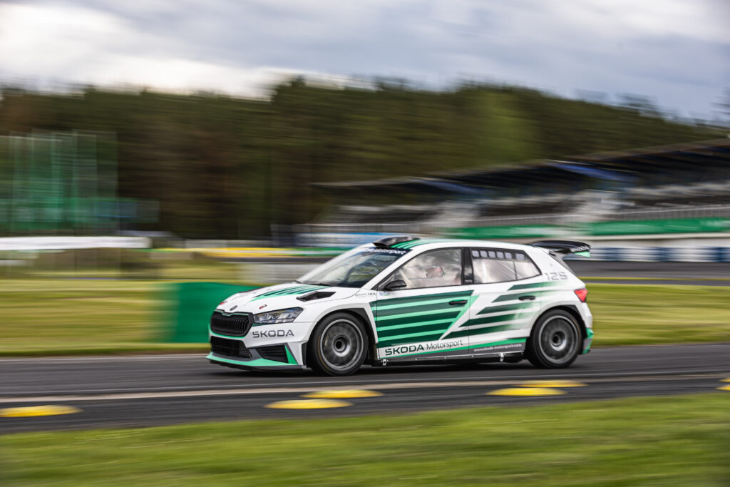 Skoda Motorsport rally car speeding on a racetrack with motion blur background.
