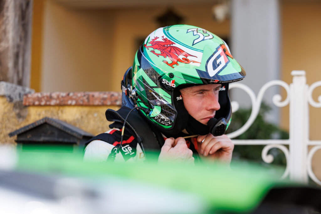 Welsh rally driver Elfyn Evans wearing a green Toyota Gazoo Racing Stilo helmet with a Welsh dragon design.