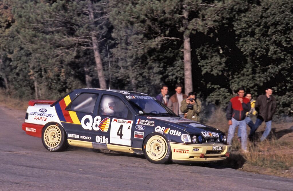 Ford Sierra RS Cosworth rally car driven by Francois Delecour with Q8 Oils livery on a road stage.