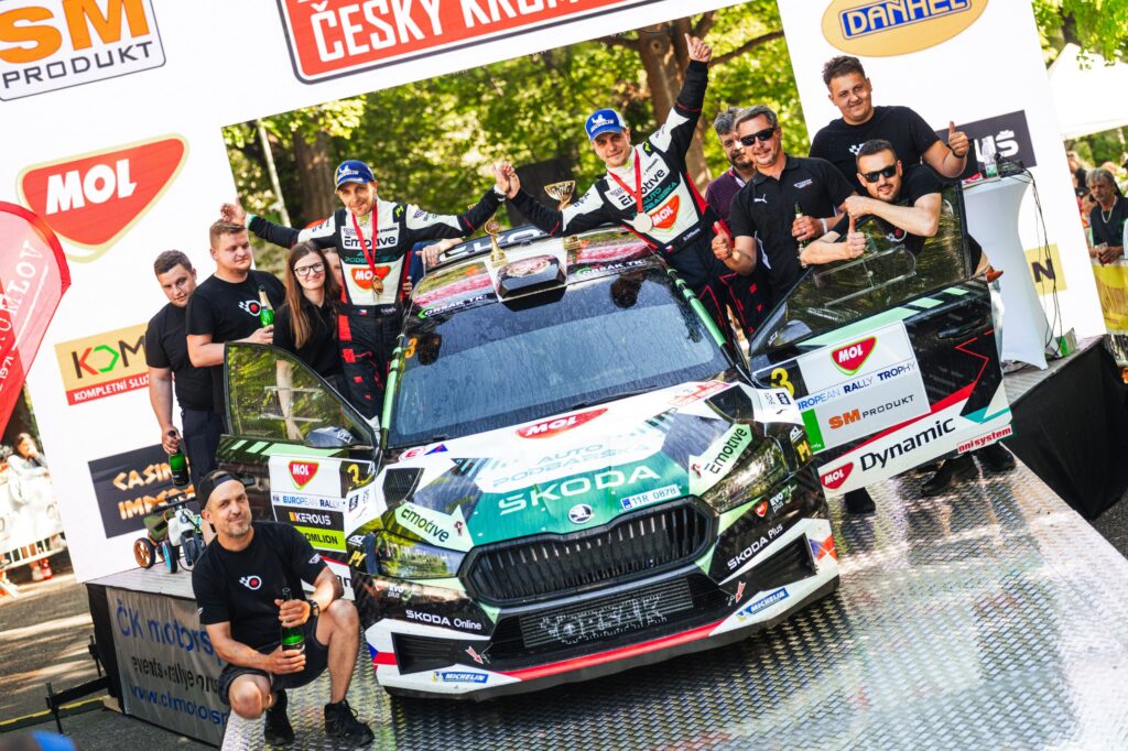 Rally drivers and team celebrate podium finish with their Skoda rally car at the European Rally Trophy.
