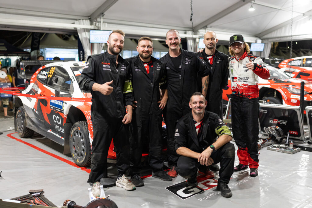WRC driver Oliver Solberg and mechanics pose with the Toyota Gazoo Racing GR Yaris Rally1 car.